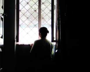 una mujer de espaldas mira por la ventana