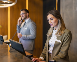dos personas trabajan en la recepción de un hotel