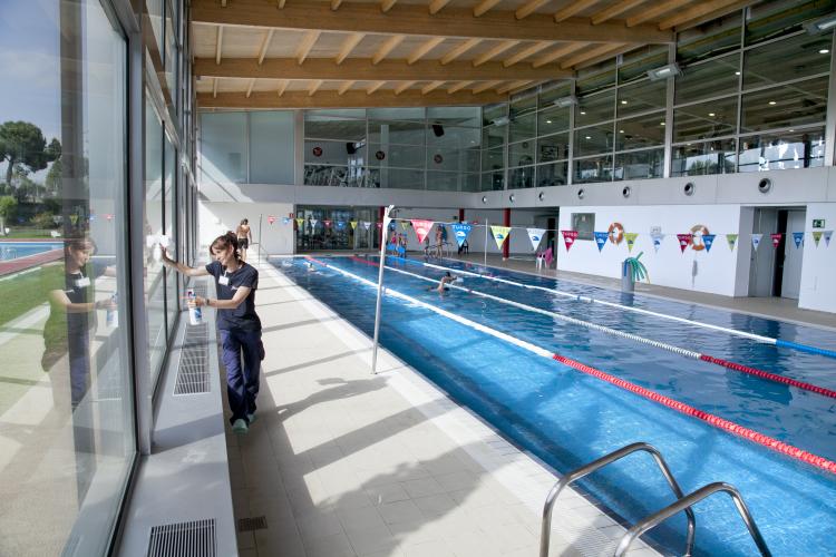 Una empleada de Grupo SIFU en tareas de limpieza en una piscina cubierta