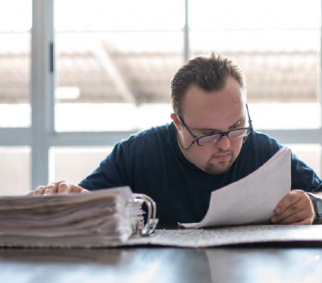 Hombre discapacitado leyendo documentación en una oficina