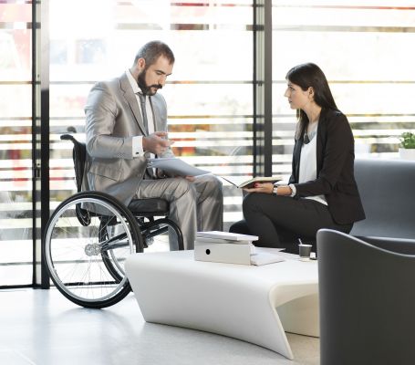 Un hombre en silla de ruedas manteniendo una reunión con una mujer