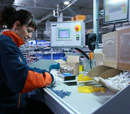 Empleada de Grupo SIFU en una mesa de montaje industrial