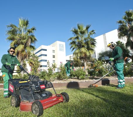 Dos jardineros de Grupo SIFU cortando el césped de una zona verde