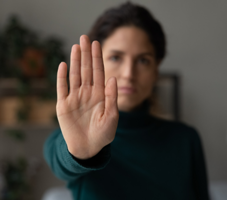 una mujer hace el gesto de 'para' con la mano