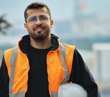 trabajo con discapacidad: un hombre con chaleco de trabajo y casco de trabajo bajo el brazo