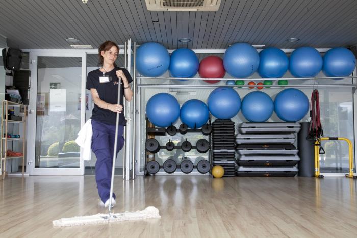 Empleada de Grupo SIFU limpiando el suelo de un gimnasio