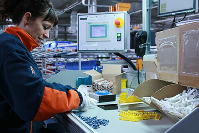 Empleada de Grupo SIFU en una mesa de montaje industrial
